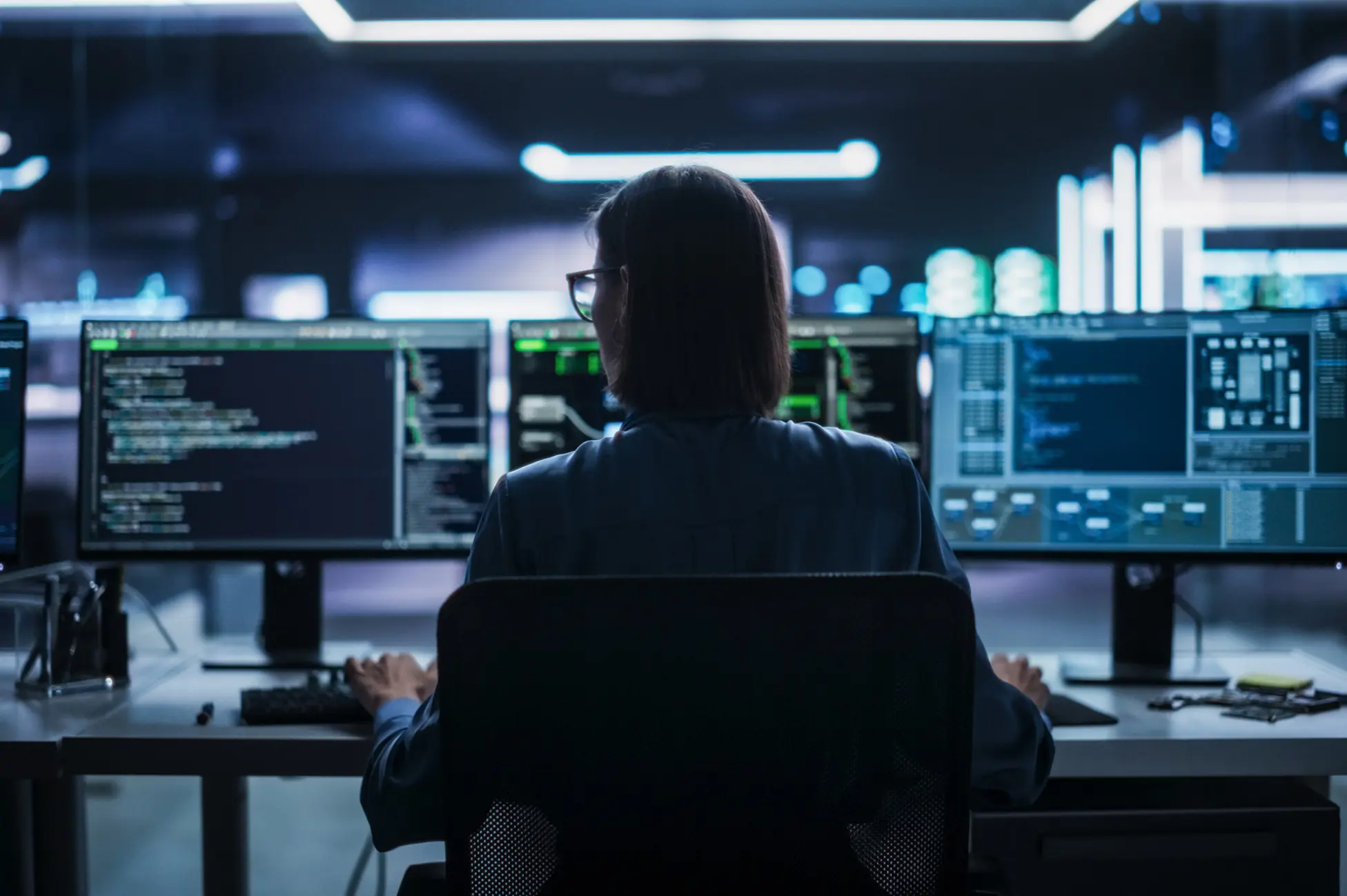 Person coding at multiple computer screens